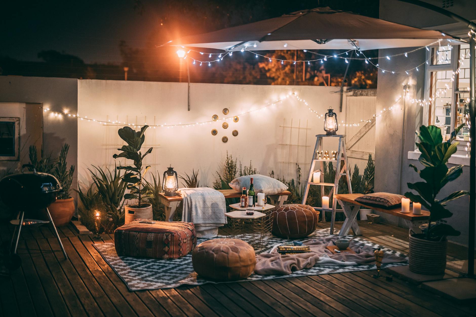 Cozy outdoor patio at night with warm string lights and comfortable seating