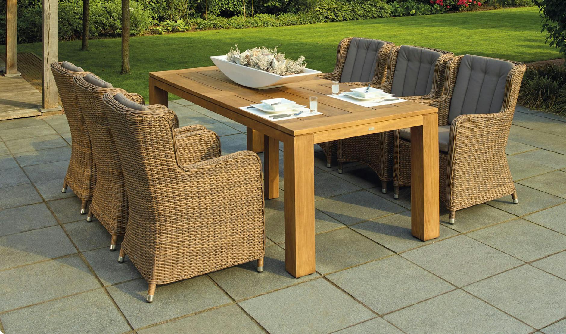 Relaxing outdoor patio with rattan chairs and wooden table for outdoor entertaining