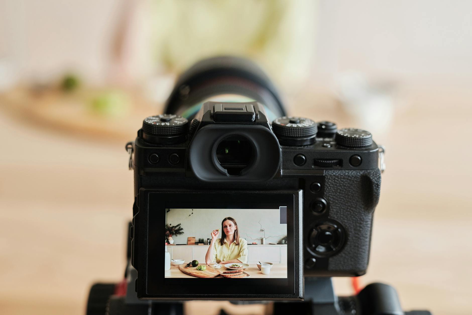 Woman vlogging in home studio kitchen setup showing consistent content creation environment