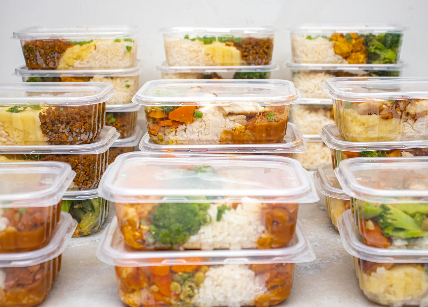 Meal prep containers filled with rice and vegetables ready for storage or freezing to cut food waste