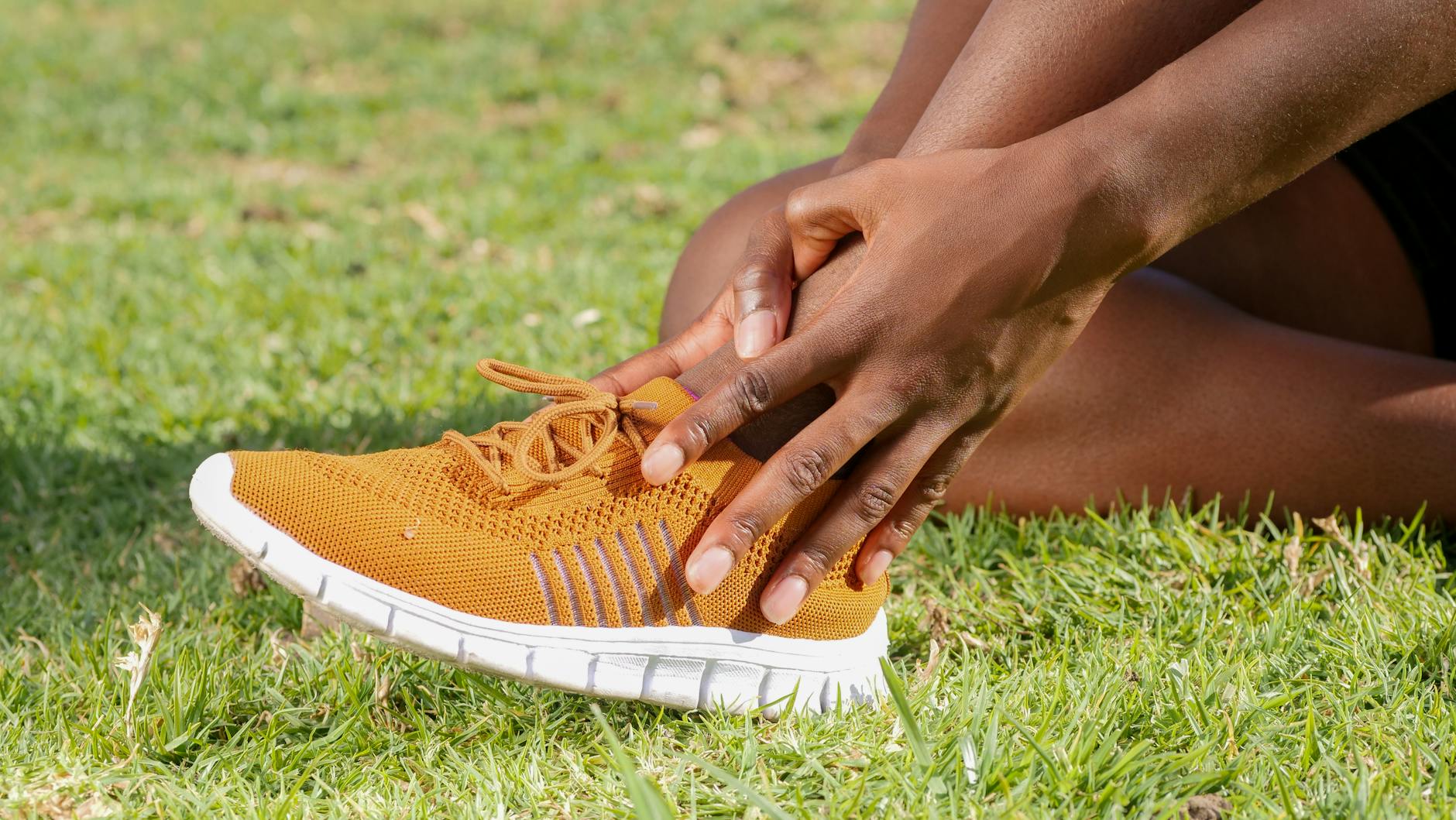 Person holding ankle showing signs of foot pain and injury