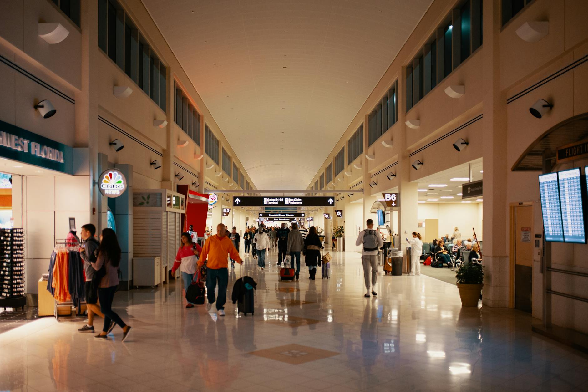 Busy airport terminal hallway with travelers passing through