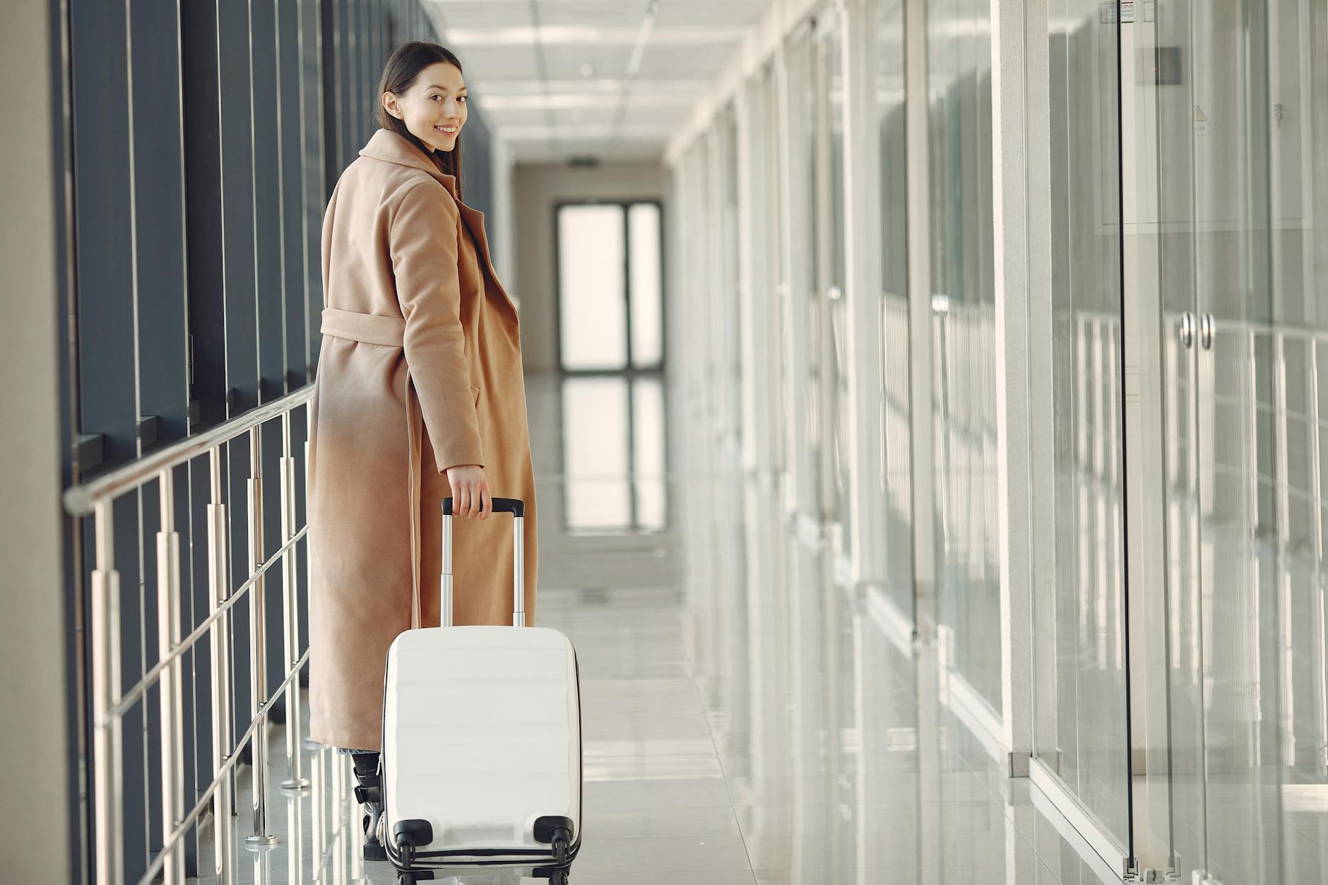 Woman walking confidently through airport terminal with suitcase