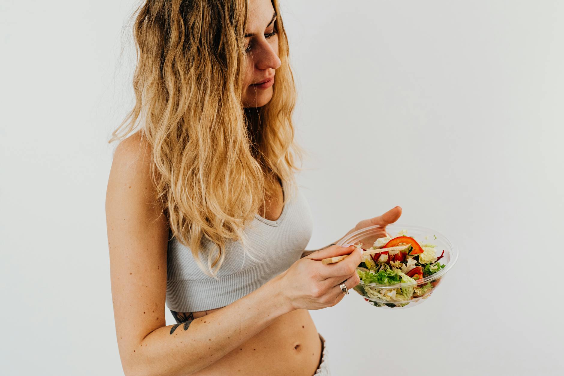Healthy Diet Supports Akkermansia Muciniphila Growth Woman eating a fresh, healthy salad to support gut microbiome and Akkermansia muciniphila levels