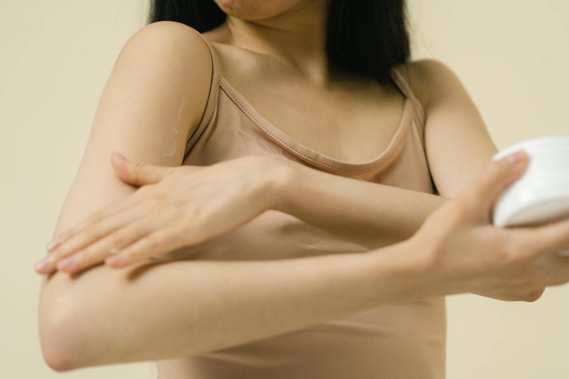 Arm Skincare Routine for Firming — Moisturizer Application Close-up of moisturizer being applied to a woman's arm as part of a skincare routine
