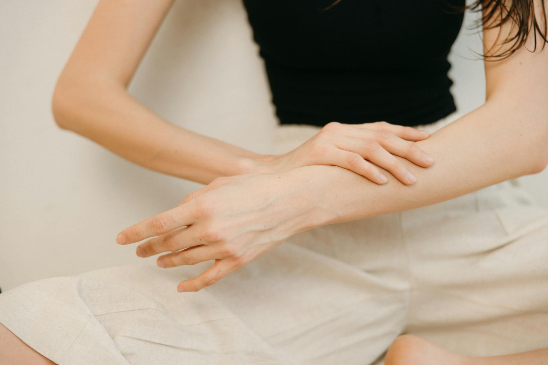 Targeted Body Care Routine for Firmer Arm Skin Over 40 Woman carefully applying skincare cream to her arm, demonstrating a targeted body care routine