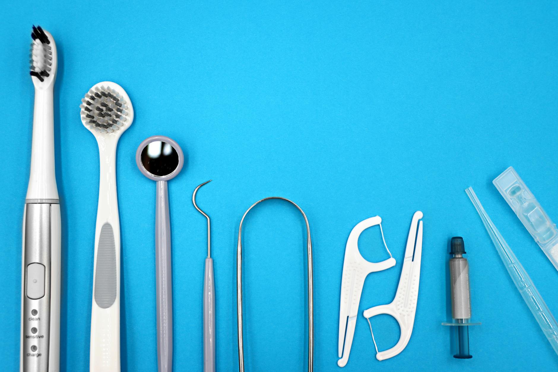 Flat lay of dental care tools including toothbrushes and floss for a complete oral hygiene routine