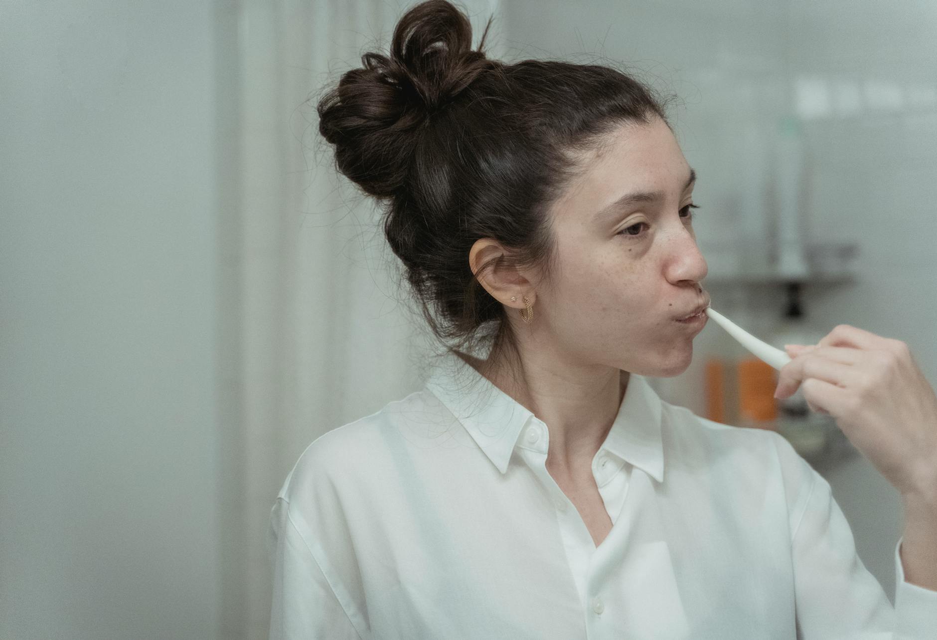 Woman brushing her teeth as part of a daily oral hygiene routine