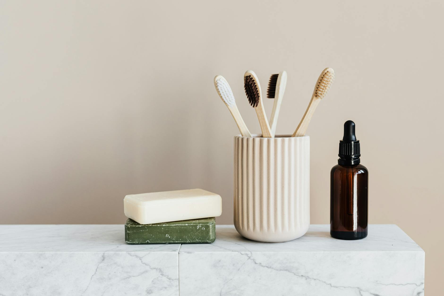 Organized eco-friendly bathroom supplies including soaps and toothbrushes on a marble surface