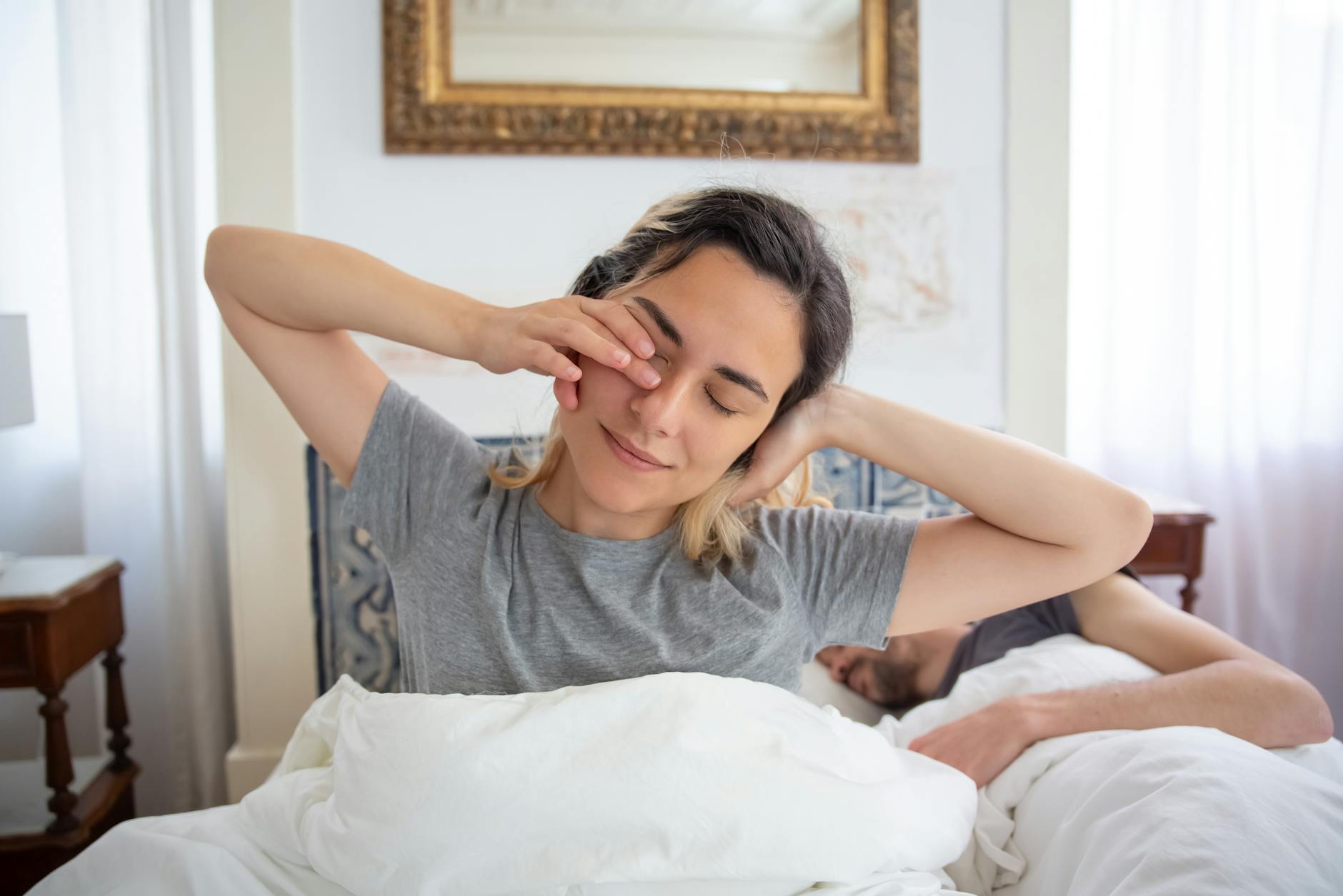 Waking Up Refreshed After Sleep Environment Optimization Young woman waking up refreshed with a morning stretch after quality sleep
