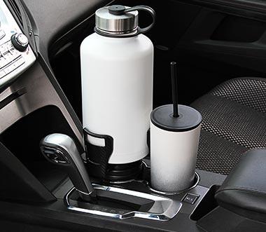 CupStation installed in car cupholder holding an oversized tumbler while driving