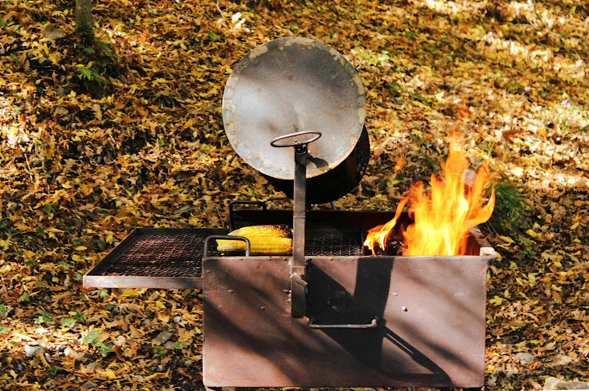 Backyard BBQ Grilling - Outdoor Entertaining Gifts 2026 Outdoor BBQ grill with fire and corn in an autumn backyard setting