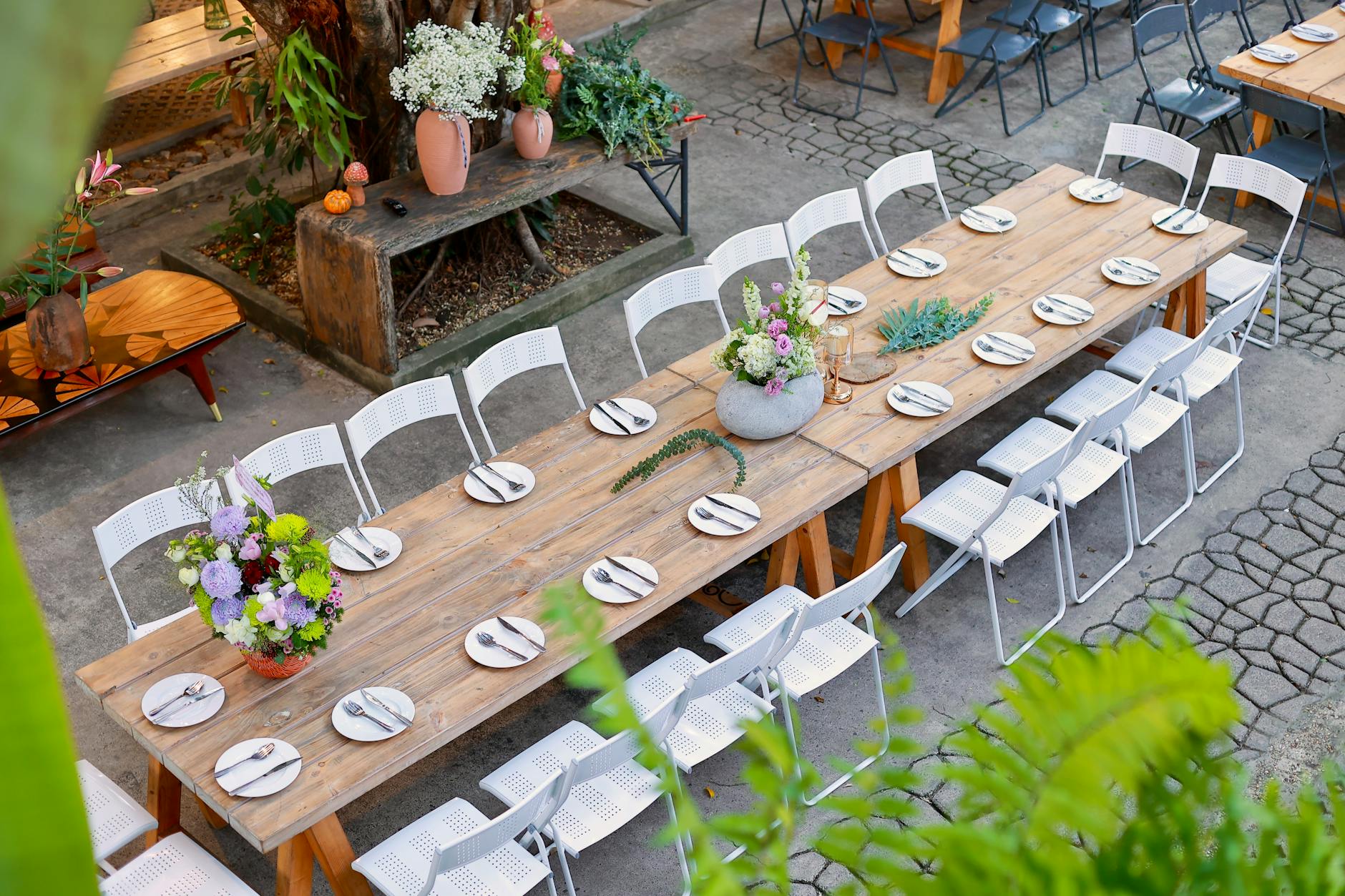Outdoor Dining Setup - Unique Gifts for Homeowners 2026 Beautiful outdoor dining table set with floral centerpieces in a garden patio