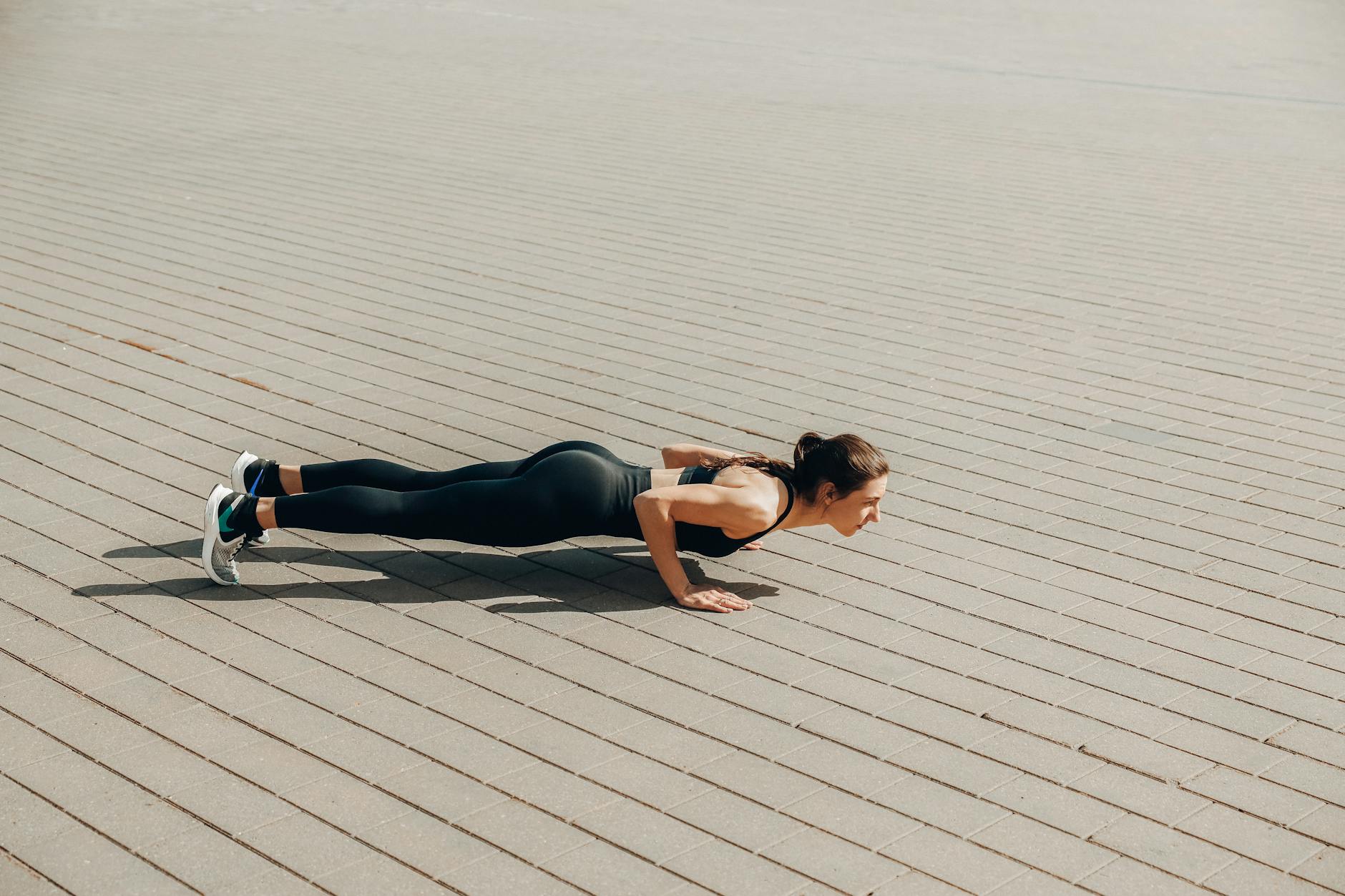 Woman performing push-ups outdoors to build upper body strength for golf