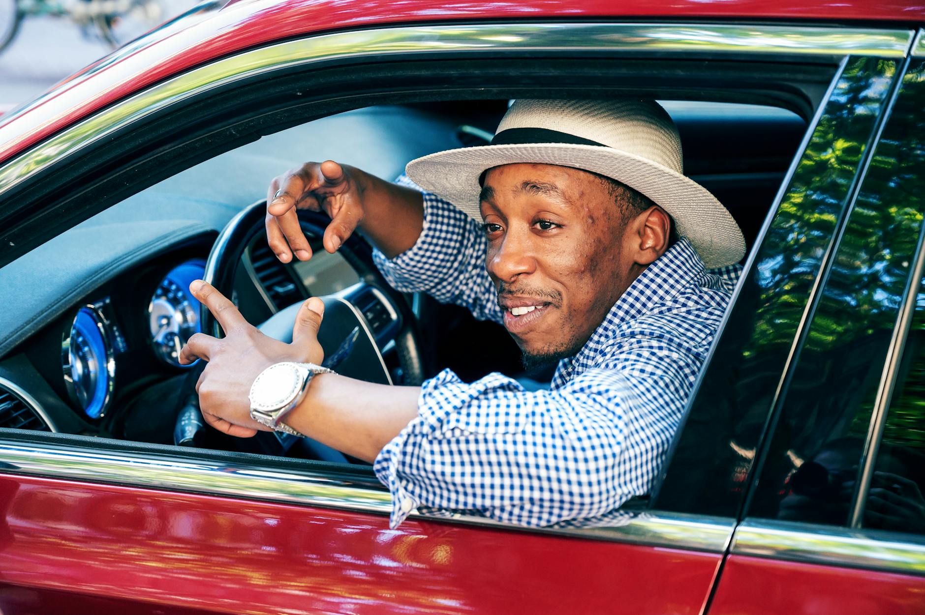 Confident driver smiling in a red car — prepared with all essential items on board