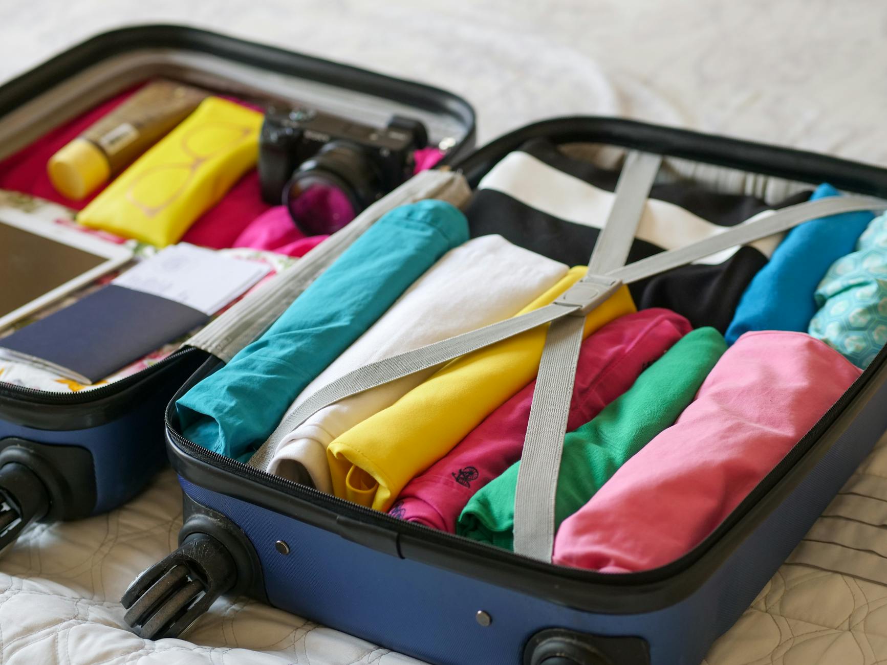 Open suitcase neatly packed with clothes and travel essentials for carry-on only travel