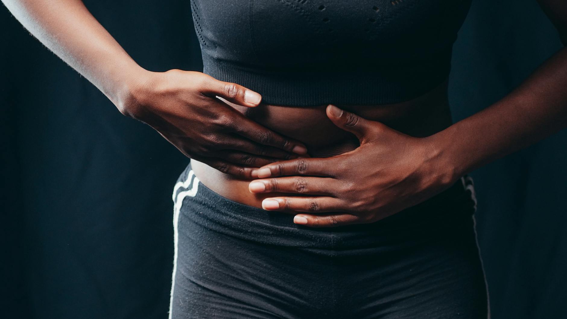Chronic Inflammation Body Pain 2026 Person holding abdomen in pain, illustrating the physical effects of chronic inflammation on the body
