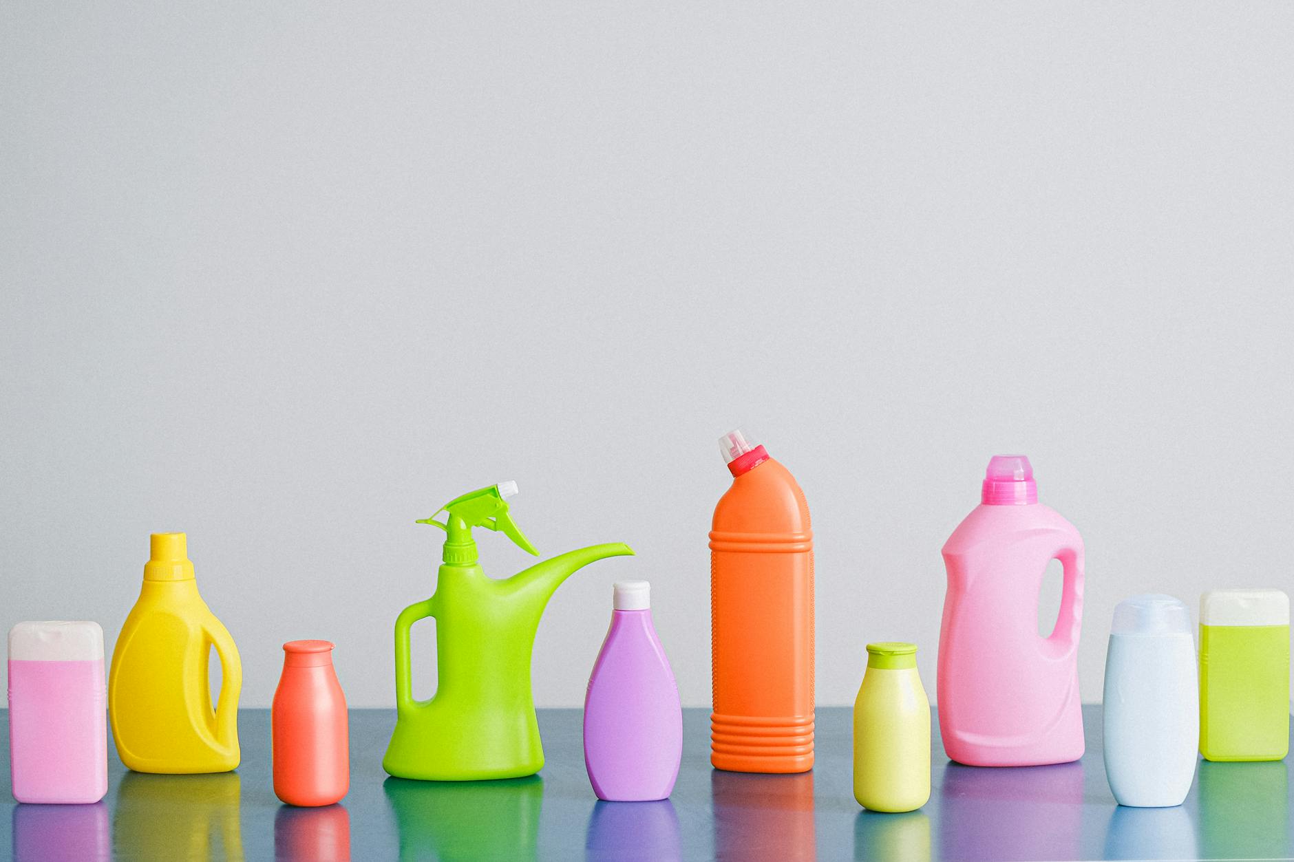 An assortment of cleaning product bottles and spray containers arranged together