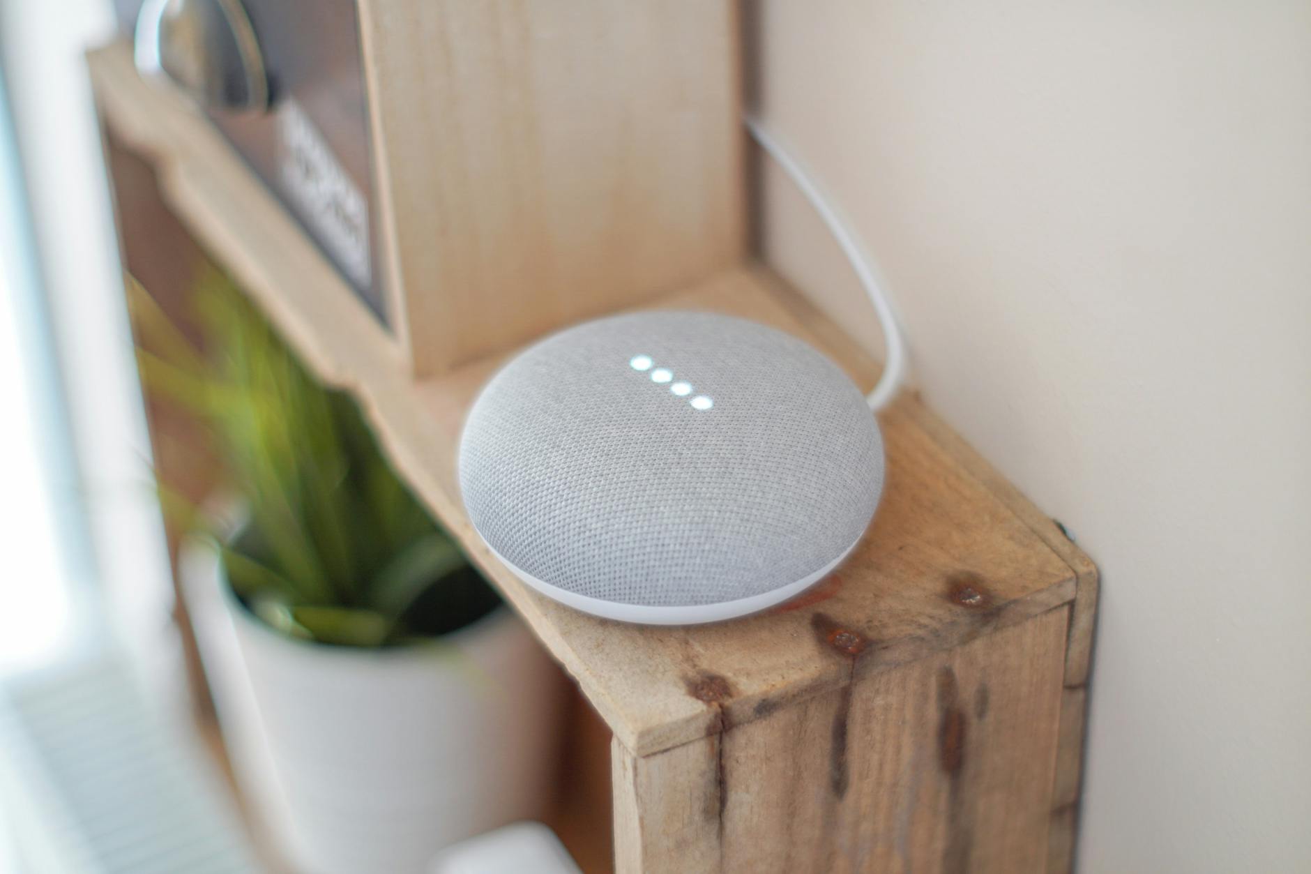 A smart home speaker sitting on a wooden shelf, representing modern connected home devices