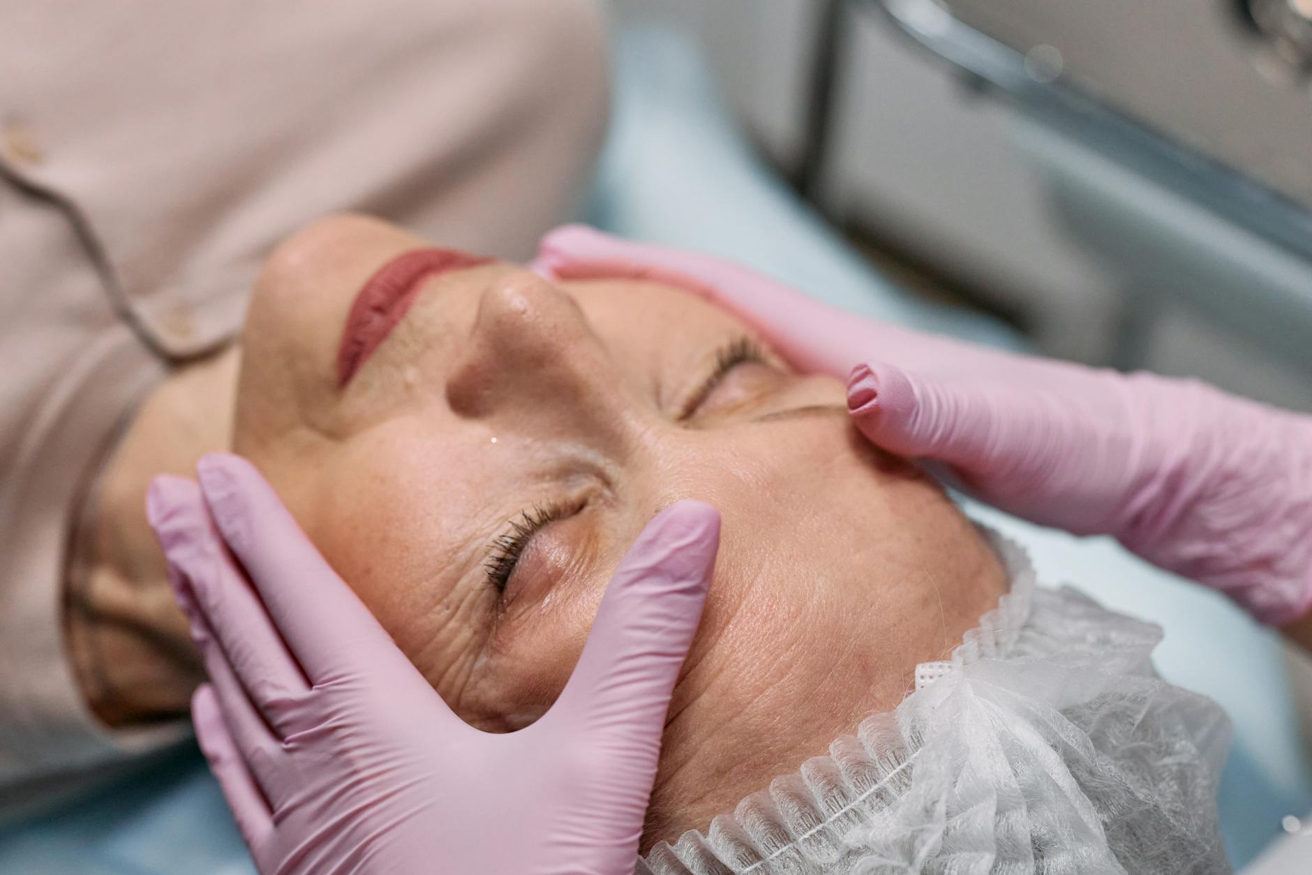 Facial massage as part of an anti-aging treatment routine Senior woman receiving facial massage treatment for anti-aging skin rejuvenation