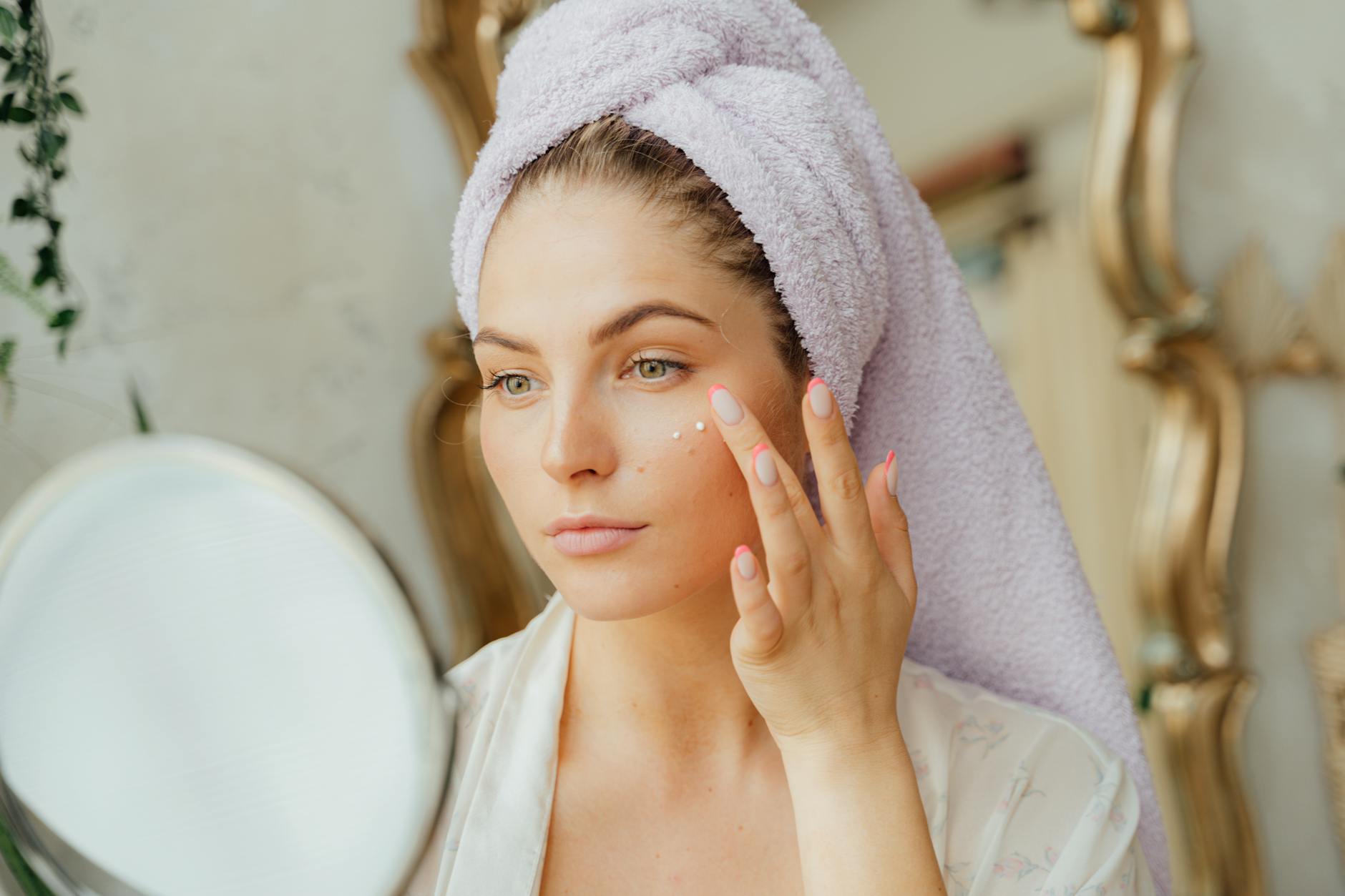 Applying eye cream as part of an anti-aging skincare routine Woman applying eye cream as part of a morning skincare routine for crow's feet