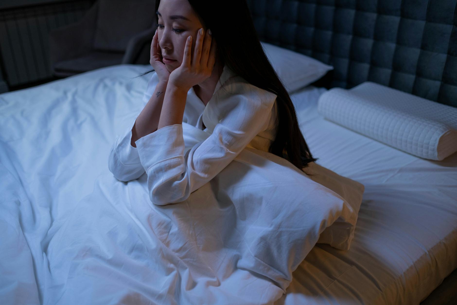 Sleep deprivation as a cause of dark circles under eyes Woman lying awake at night experiencing insomnia, a key cause of lifestyle dark circles