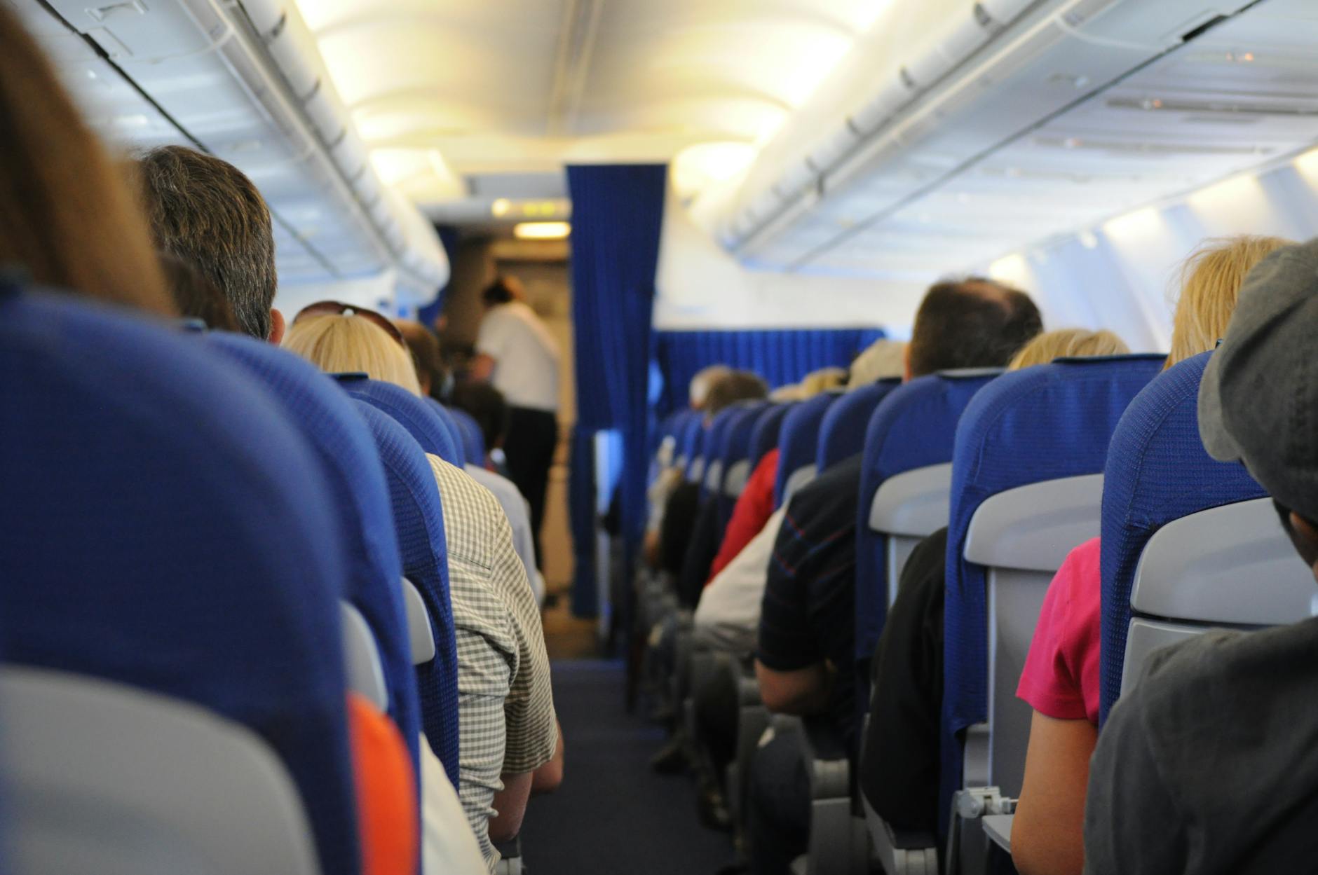 Passengers seated in an airplane cabin during a long-haul flight, illustrating DVT risk from prolonged sitting