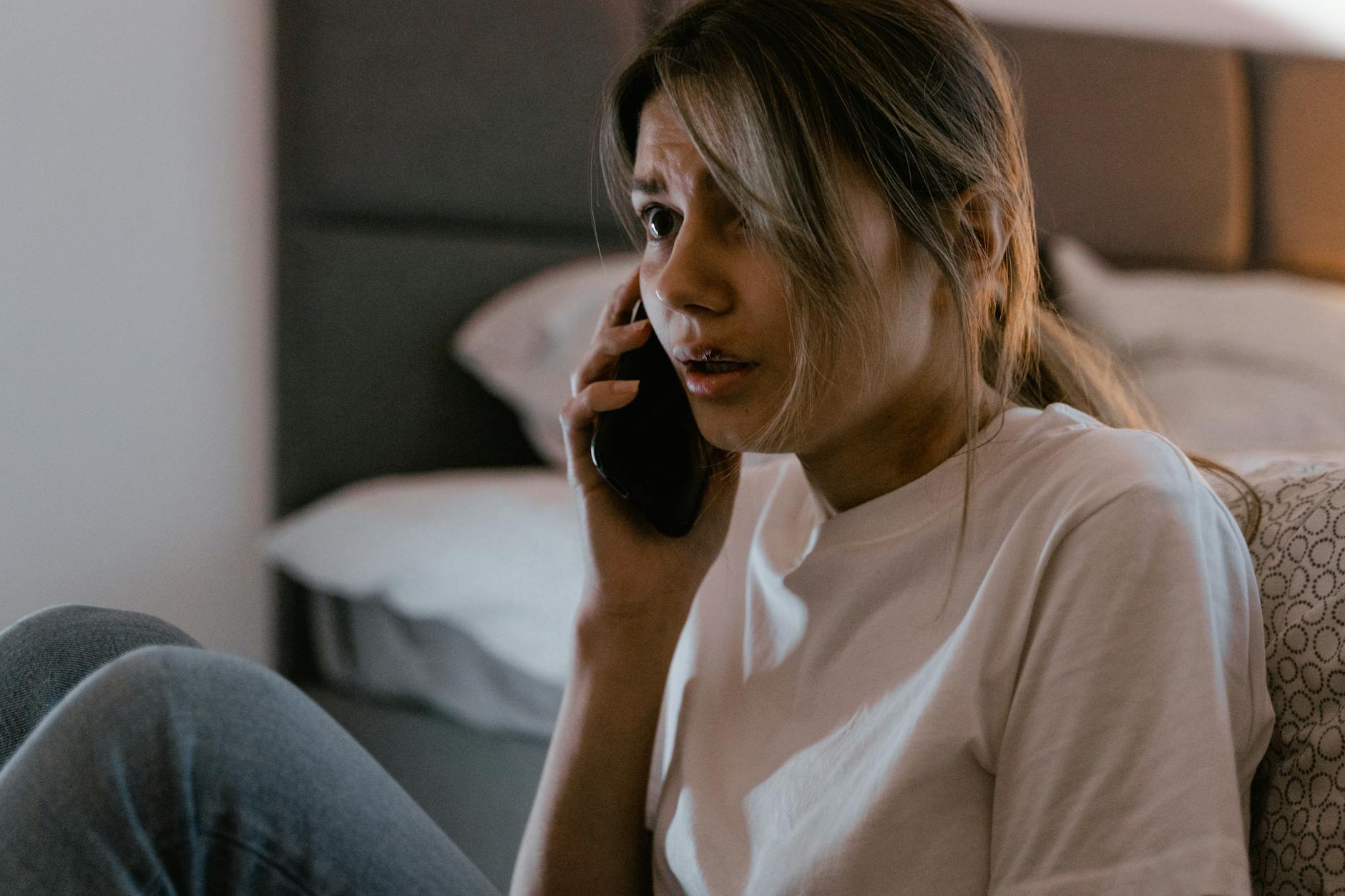 Emergency Phone Call - Why Charged Phones Save Lives Woman making a distressed emergency phone call indoors