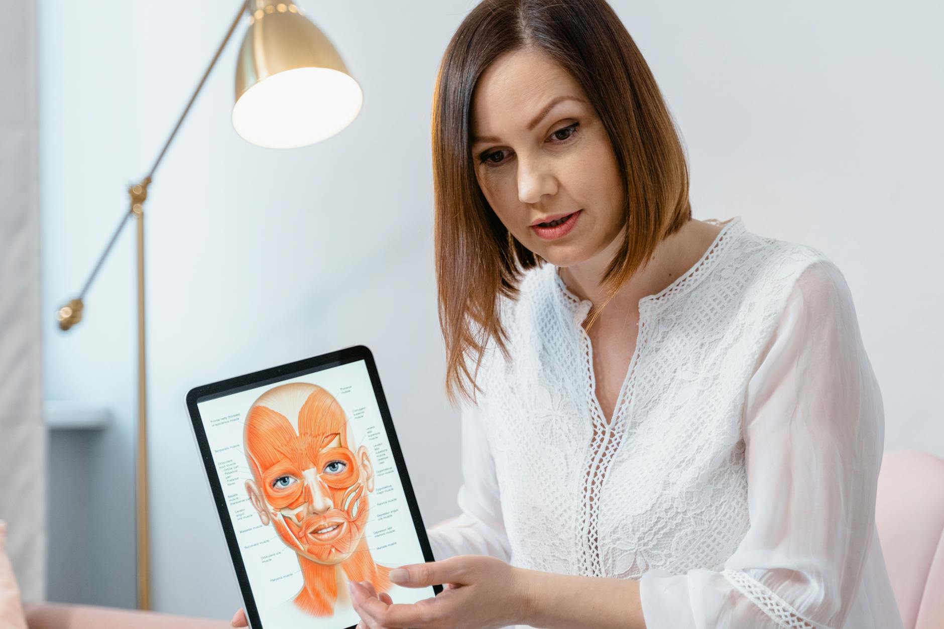 Clinician explaining facial anatomy and microcurrent treatment options to a patient