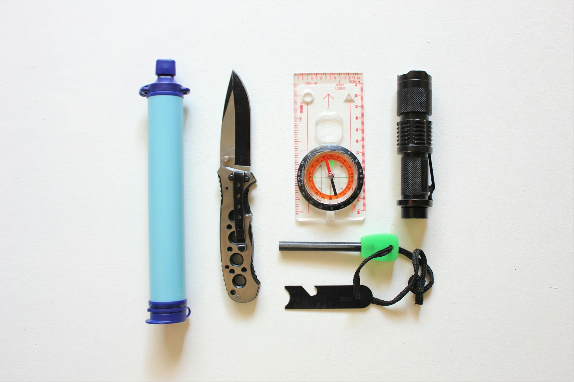 Essential Hiking Survival Kit Items 2026 Flat lay of essential survival kit items for hiking including first aid and navigation tools