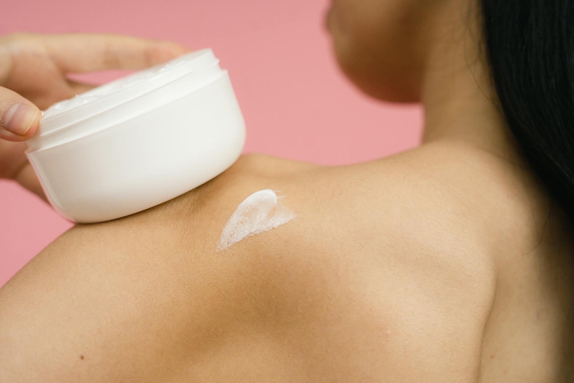 Moisturizing After Exfoliation — The Critical Recovery Step Woman applying moisturizer to skin after exfoliation
