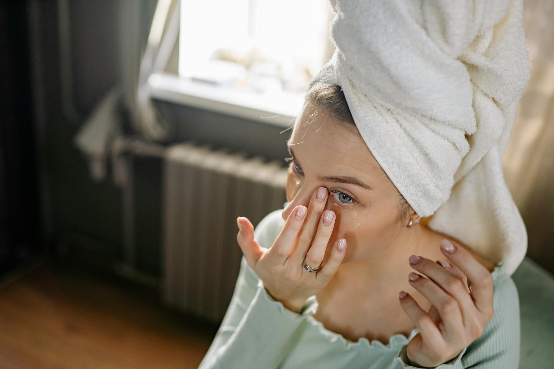Under Eye Skincare Application Routine Woman applying under-eye patches as part of her anti-aging skincare routine