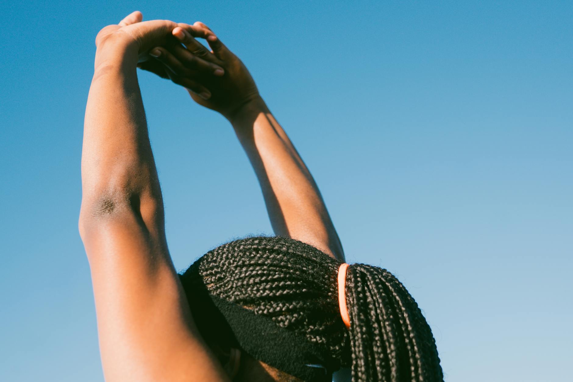 Person performing a stretching exercise outdoors as part of a foot and lower leg strengthening routine