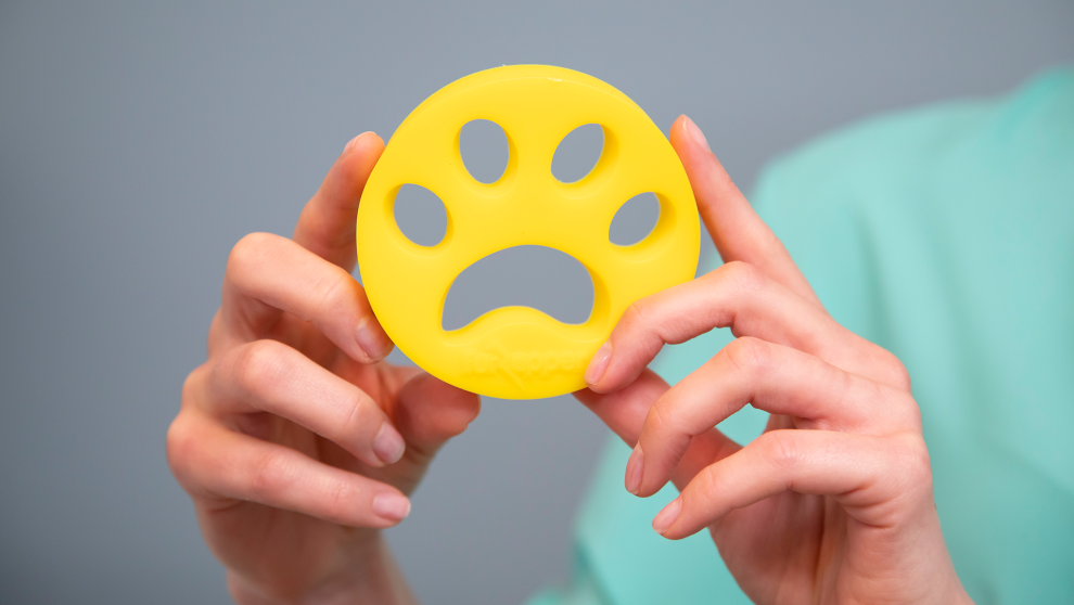 FurZapper being used in a laundry load with pet hair visibly collected on the disc surface