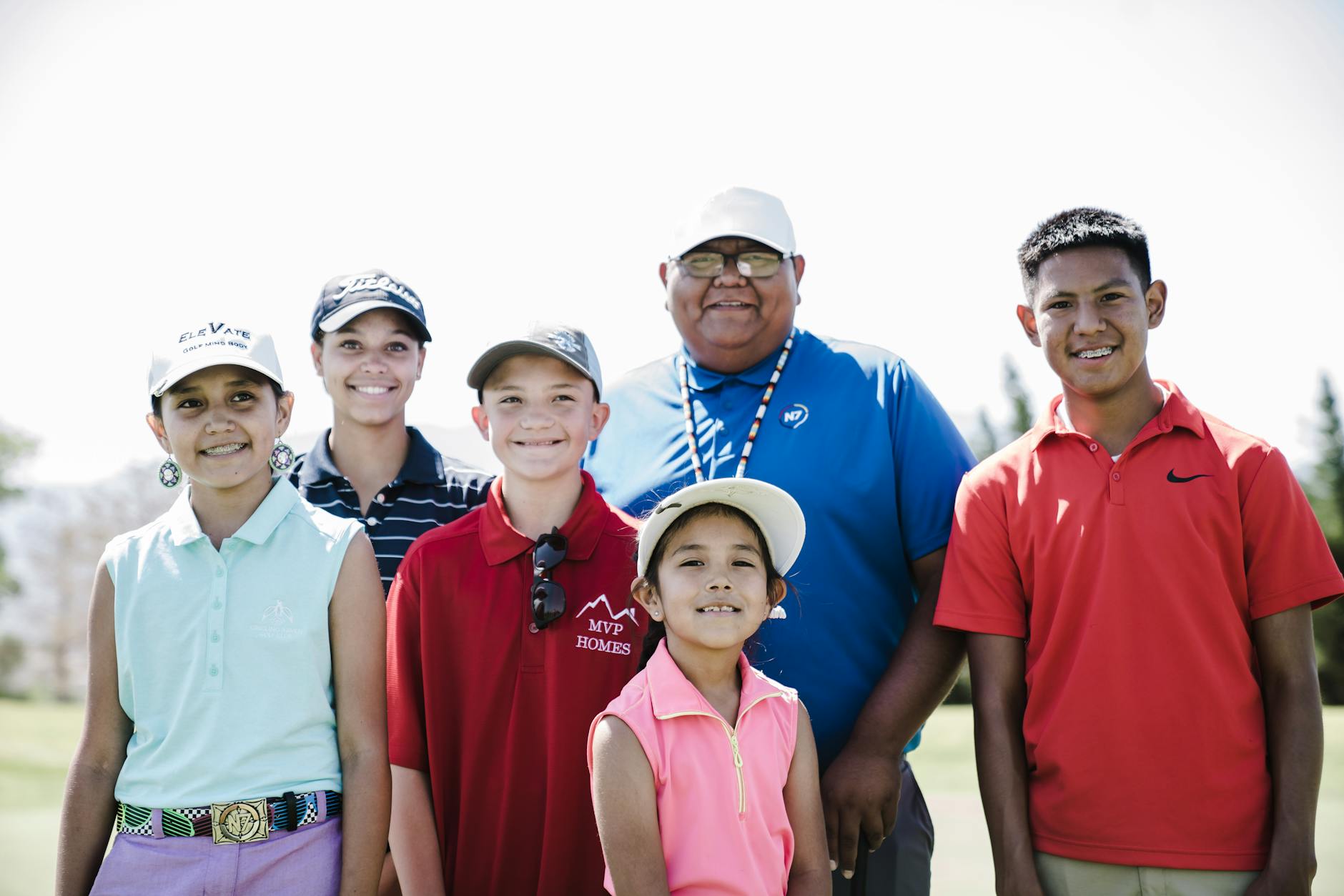 A group of friends enjoying a sunny round of golf together, sharing a laugh on the fairway