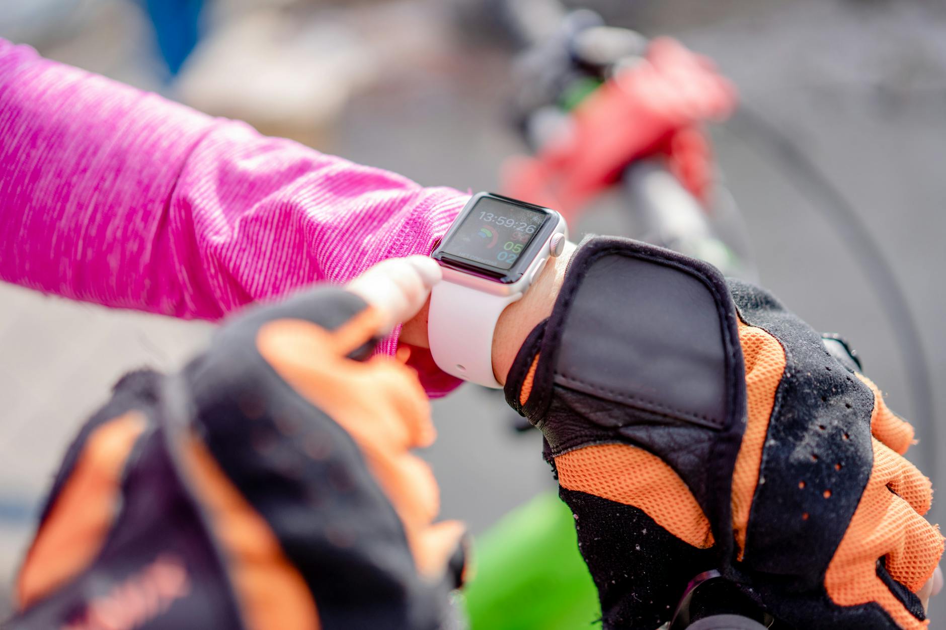 Cyclist checking a smartwatch during exercise outdoors