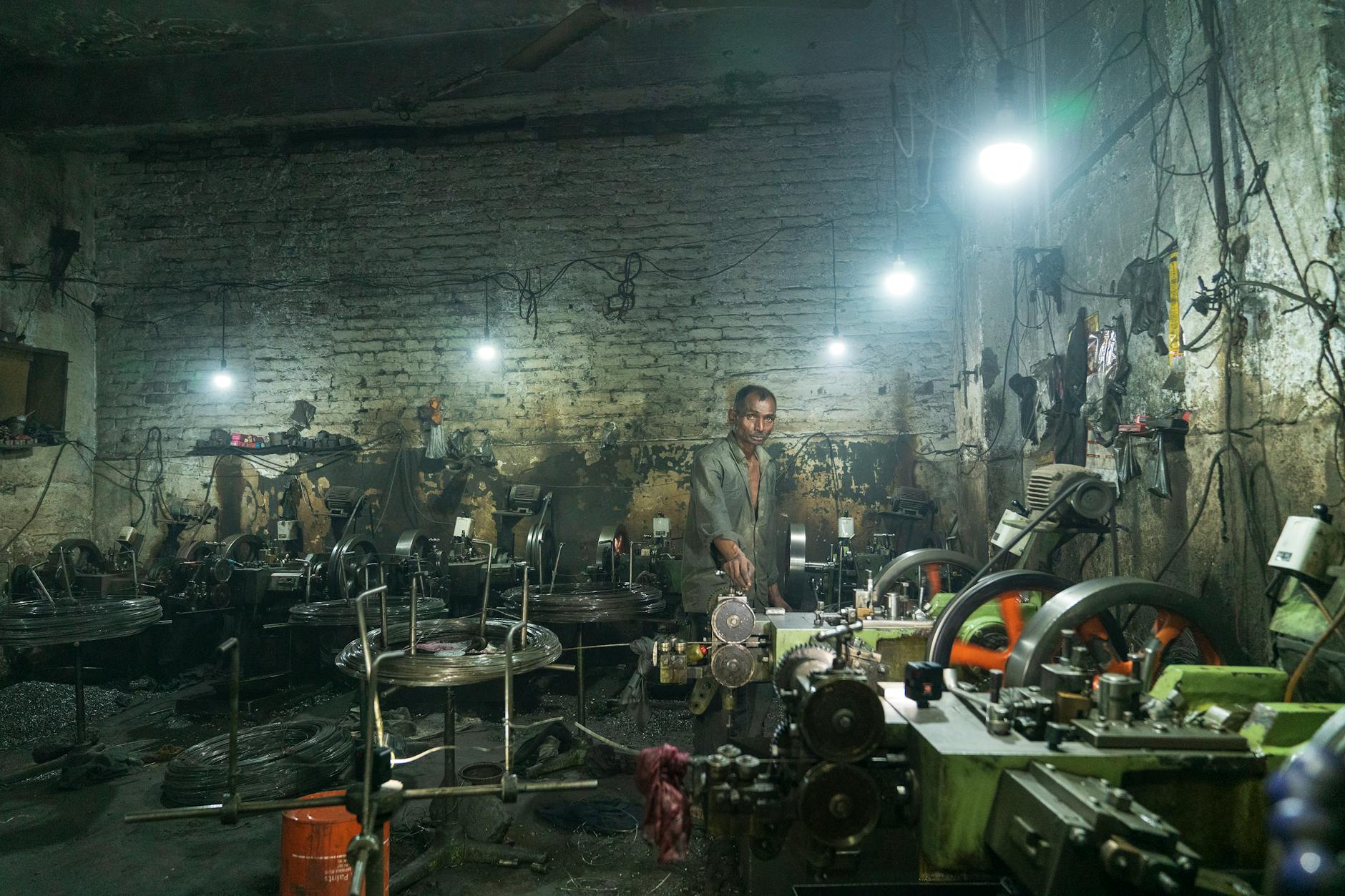 Factory worker near loud industrial machinery — similar noise levels to subway trains