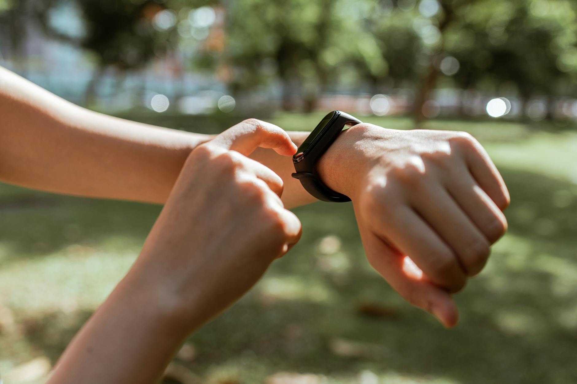 Person checking fitness wearable outdoors — tracking health and HRV data
