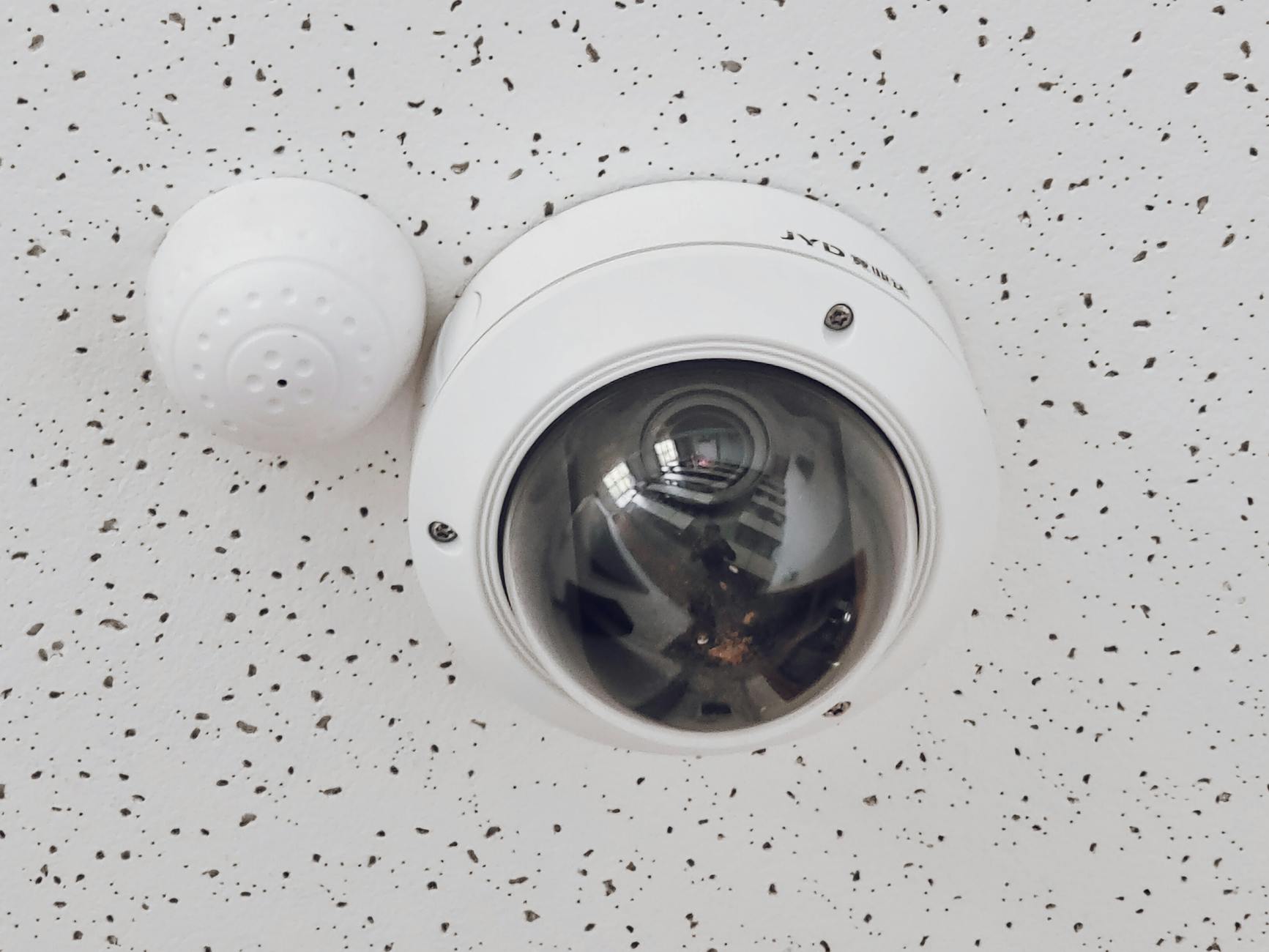 Dome surveillance camera mounted on ceiling — modern home monitoring