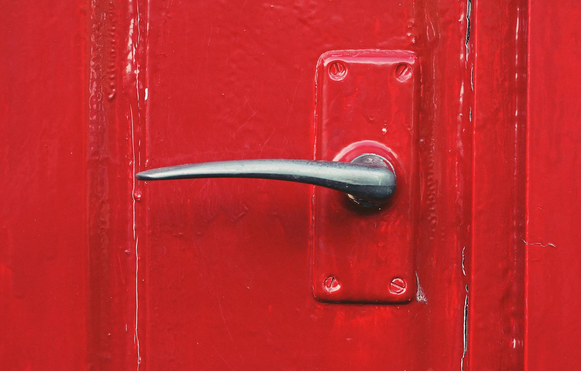 Secure Front Door Entry Point Secure red front door with metallic handle showing professional entry point