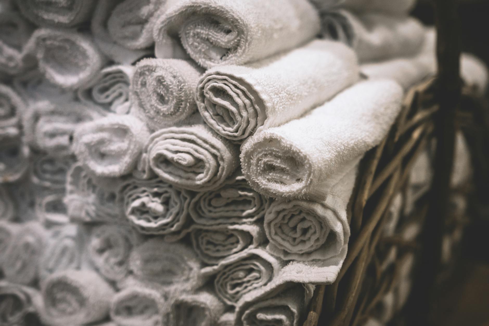 Neatly organized clean white towels in a bathroom, representing a clean and well-maintained bathroom