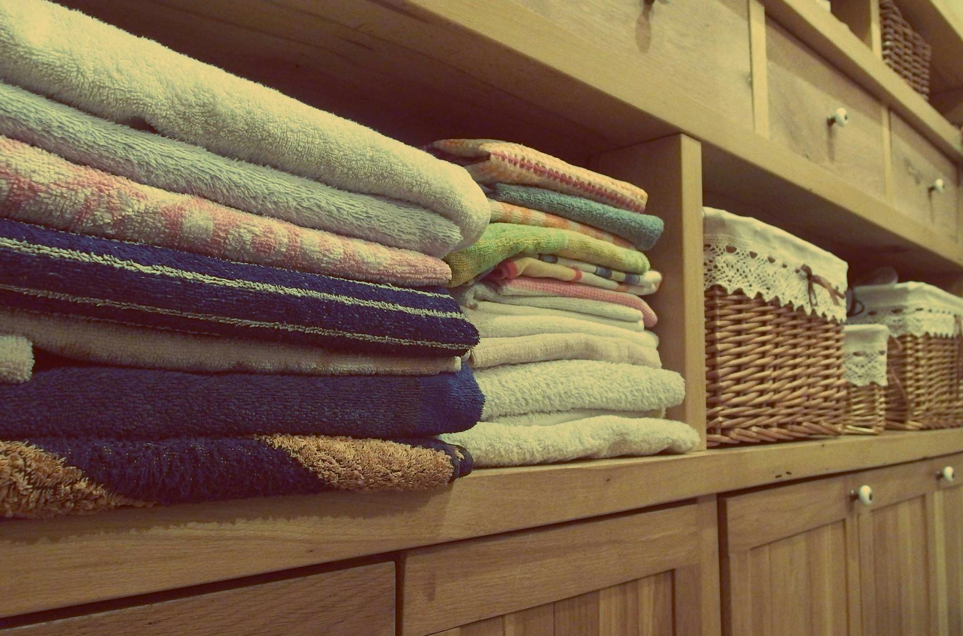 Organized Linen Closet Sheet Storage Tips 2026 Neatly organized linen closet with stacked towels and folded sheets in wicker baskets