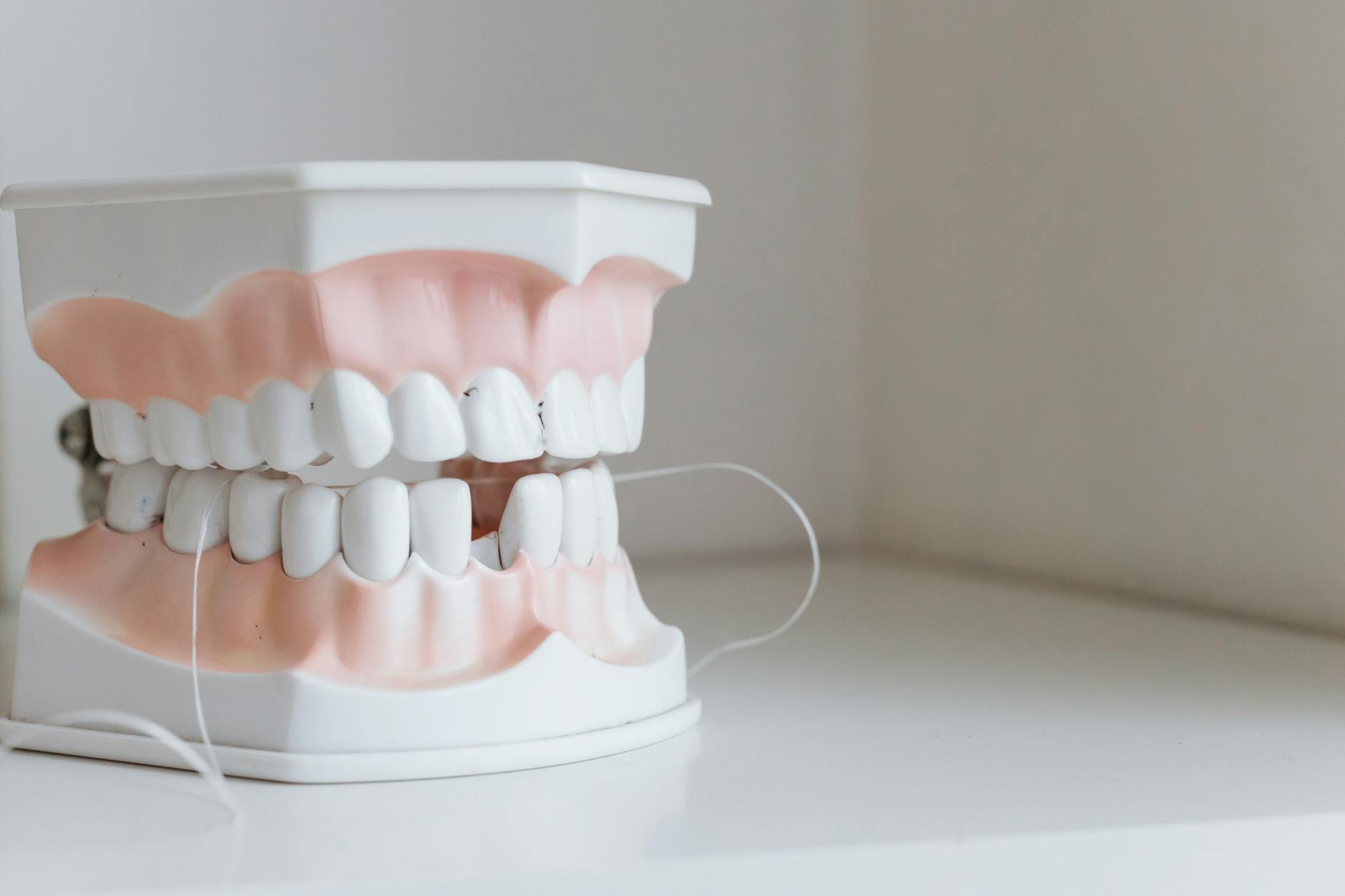 Dental hygiene tools including floss and toothbrush laid out on a surface
