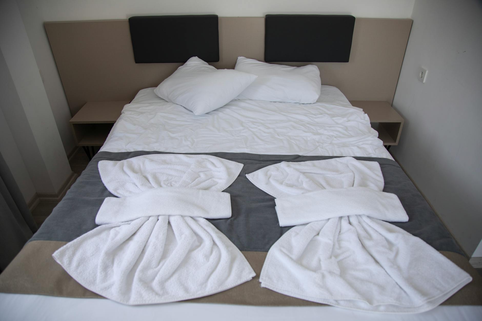Hotel Bed Pillow Arrangement and Layering Neatly arranged hotel bedroom with symmetrically placed pillows and crisp white bedding