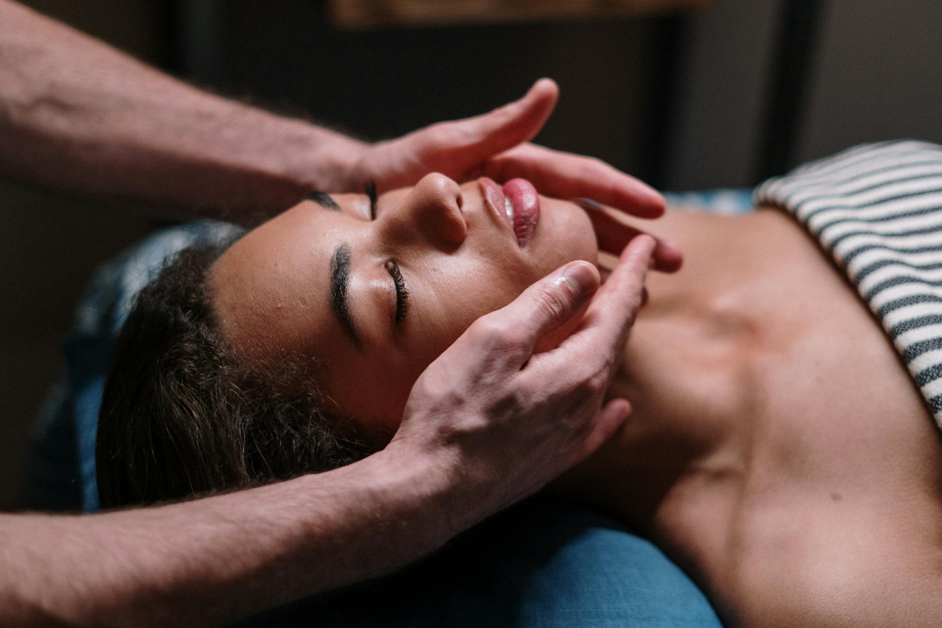 Woman receiving facial massage at spa demonstrating massage techniques for skincare absorption