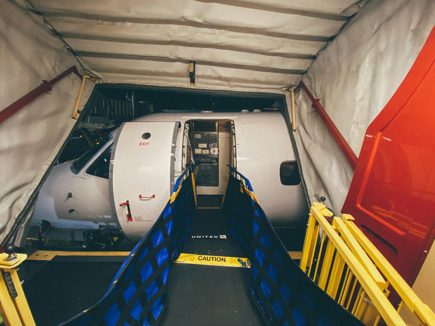 Airport Gate Boarding Tips to Avoid Carry-On Fees 2026 Airport boarding bridge leading to aircraft cabin door at the gate
