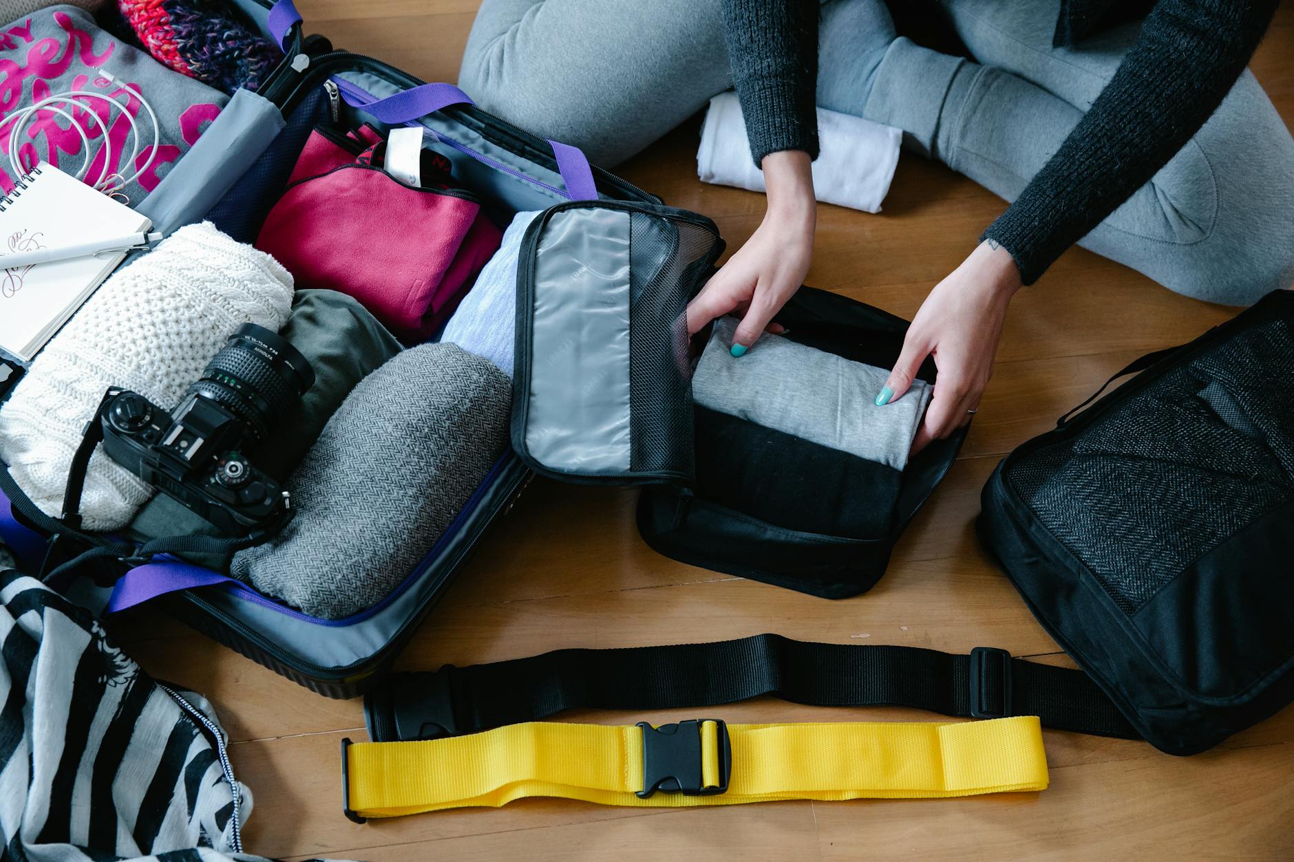 Smart Carry-On Packing Strategy for Travel 2026 Woman carefully packing and organizing a suitcase with travel essentials before a trip