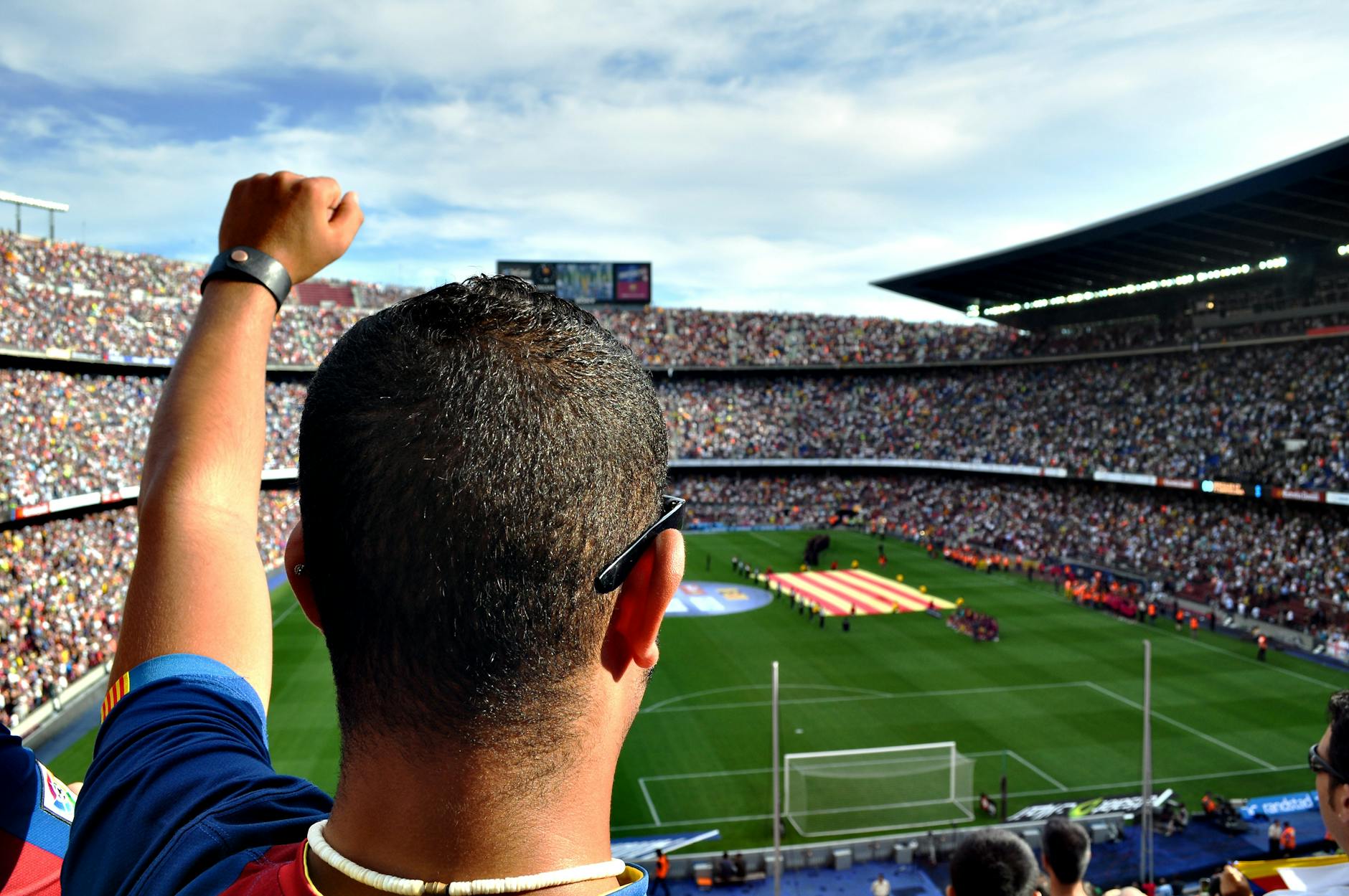 Champions League Away Day Fan Experience 2026 Passionate football fan cheering in a full stadium, waving a scarf in the electric matchday atmosphere