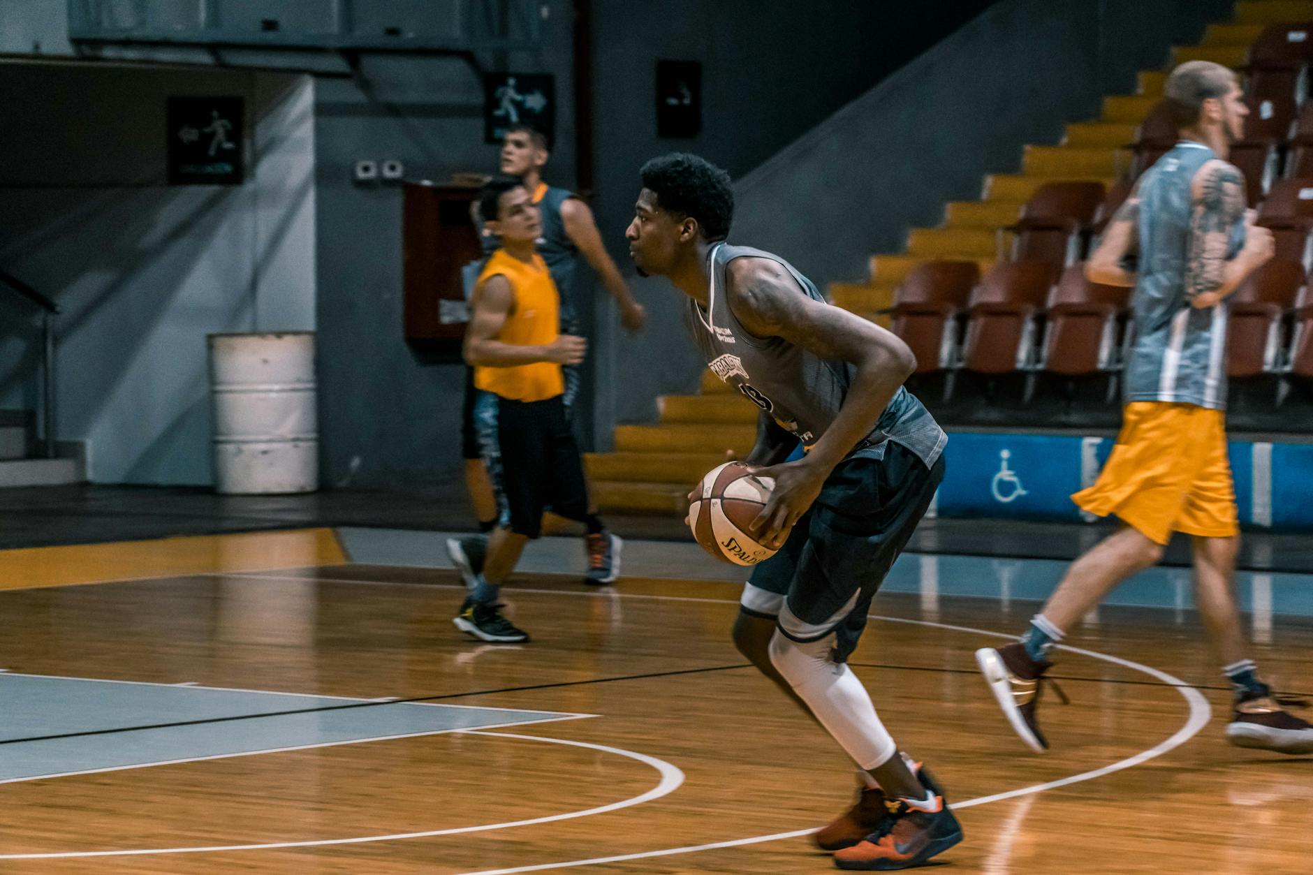 Basketball Players Indoor Court Training Basketball players training on an indoor court under bright lights, developing their skills