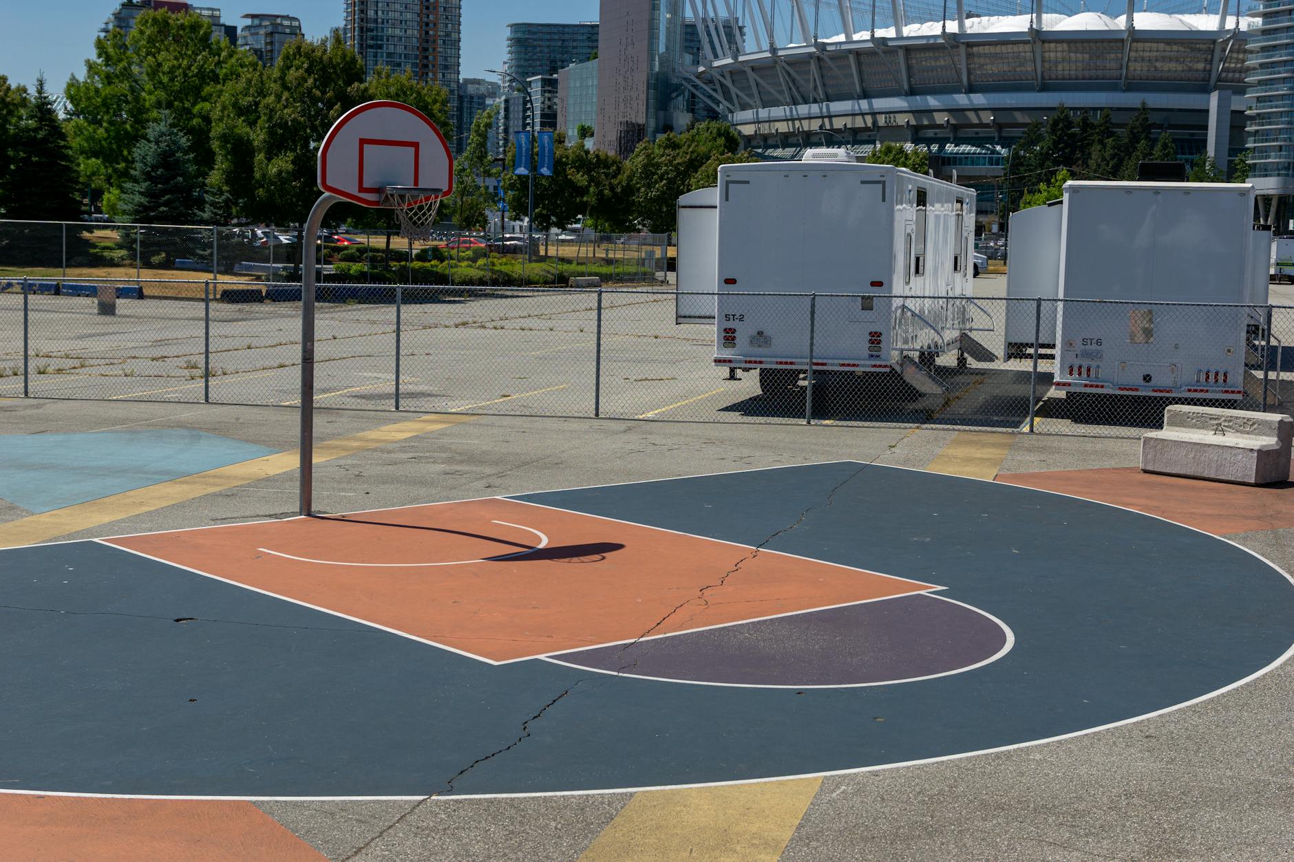 Urban Basketball Court and Stadium Setting Outdoor basketball court in an urban setting with city skyline in the background